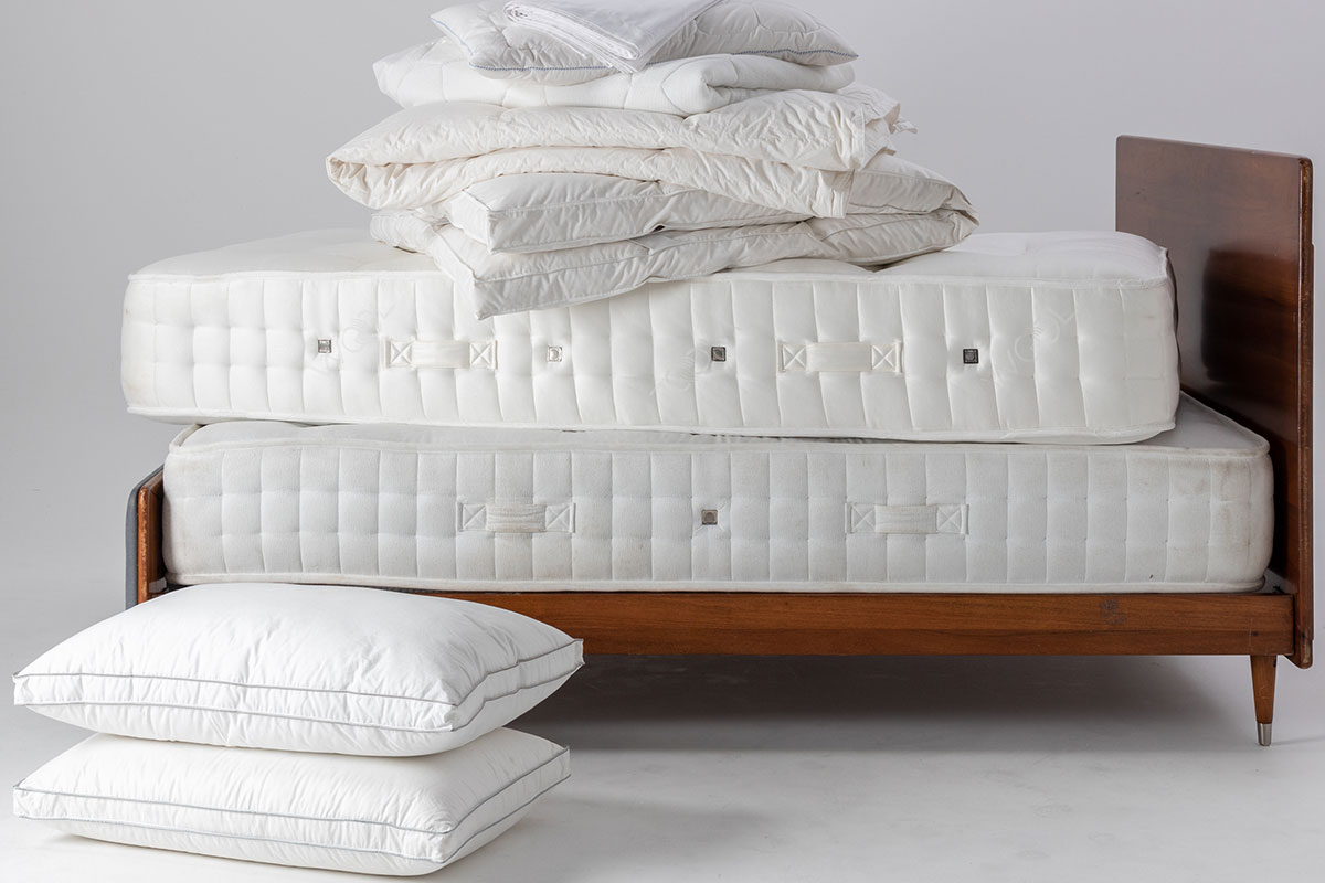 A pile of mattresses on a dark bed frame