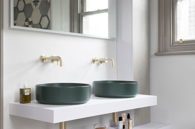 Double vanity with green basins and large mirror