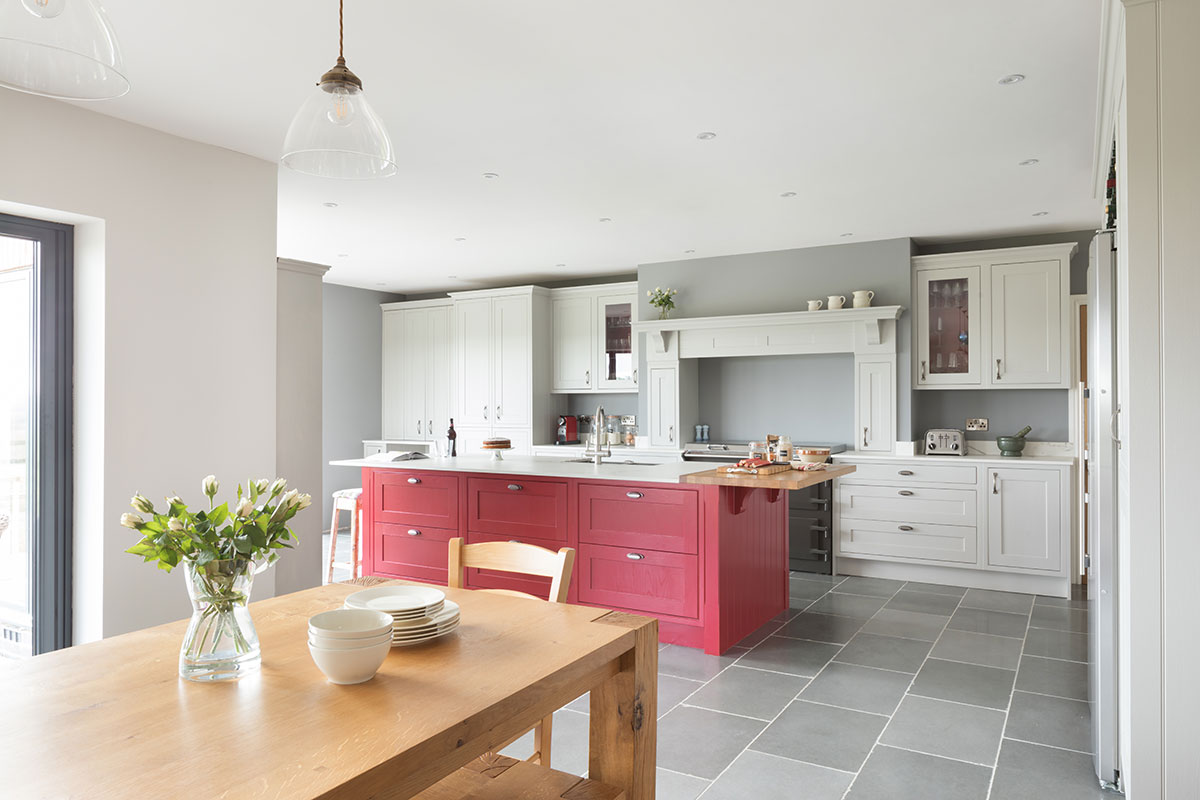 red kitchen island next to oak table