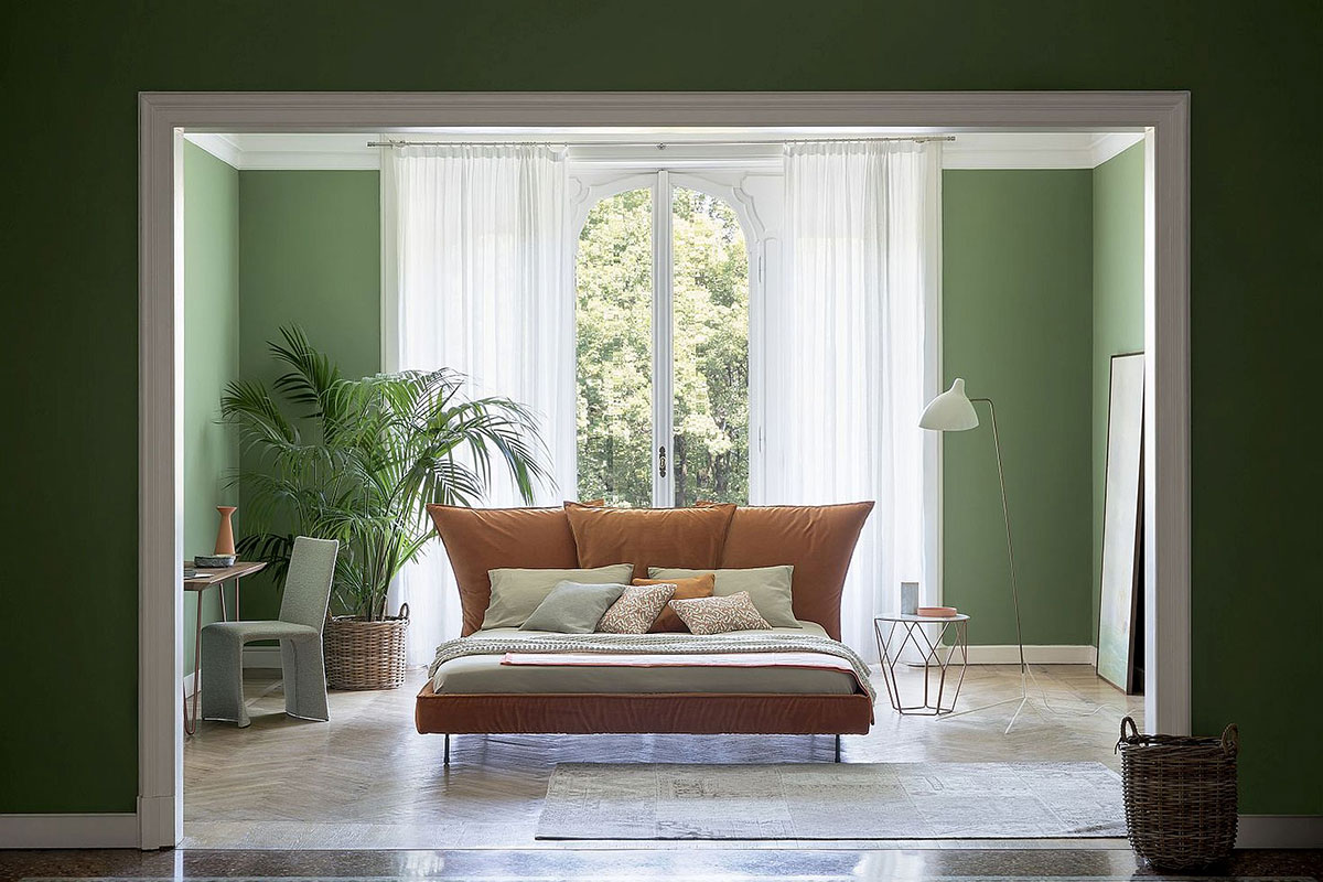 Bedroom with green walls and brown bed