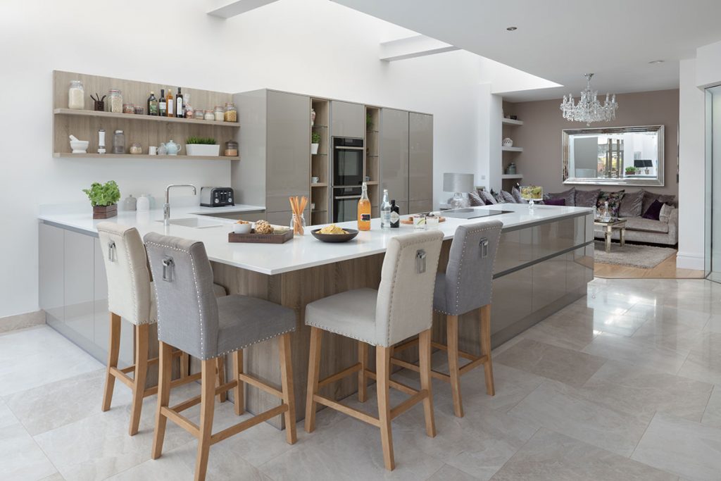 Masterclass grey design with white and grey bar stools at a wooden and white island with open shelving and black appliances