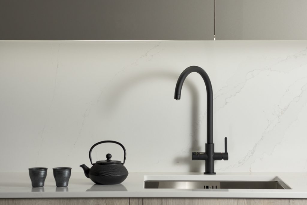Matt black boiling-water tap with u-spout in a grey kitchen