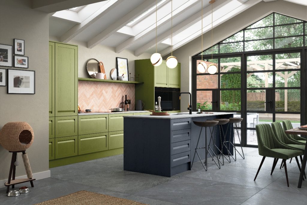 built-in appliances encased in lime green and navy kitchen cabinetry with four brass pendant lights above a large island