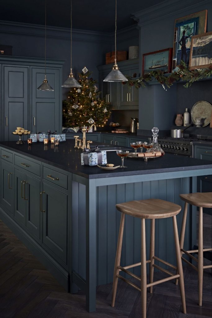 Christmas decorating ideas in dark kitchen with small tree and foliage