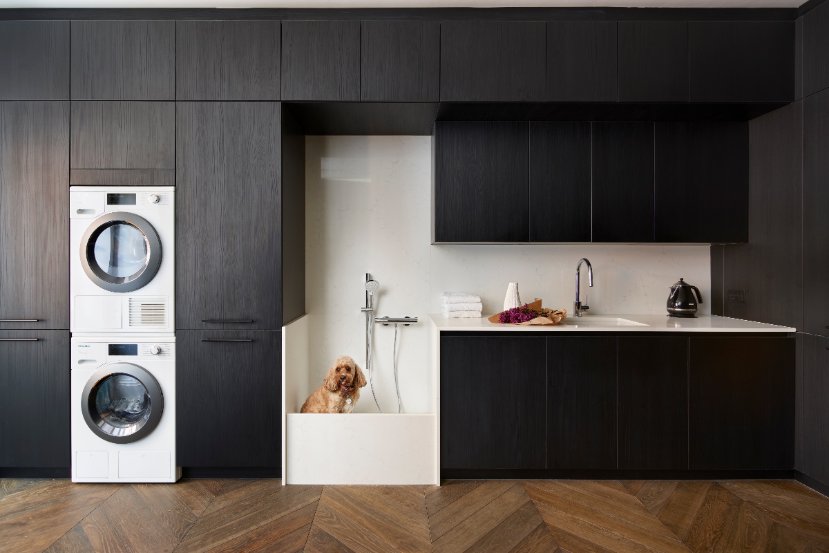 modern utility room with sleek black wood units, white appliances, pet shower and chrome brassware