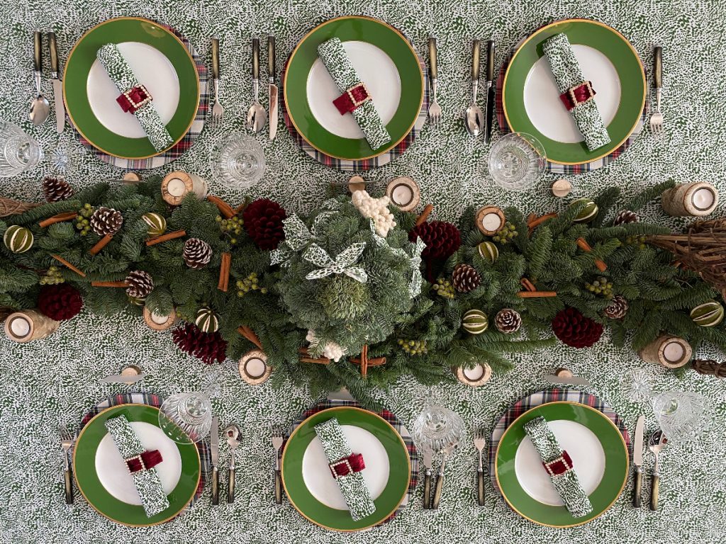 Maximalist Christmas tablescaping ideas with green plates and lots of pine cones