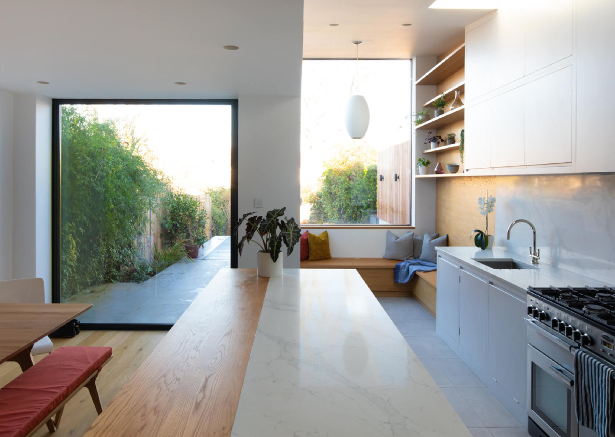 window seat with concealed storage underneath in light-filled kitchen 