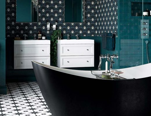 a maximalist bathroom featuring a black bath, two white double basins and monochrome tiles