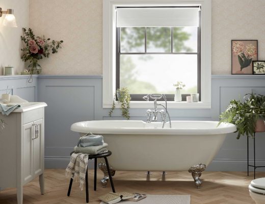 a modern rustic bathroom featuring a white roll top bath with silver claw feet