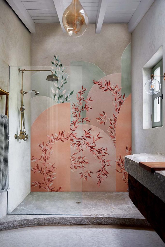 floral red, pink and green shower walls behind a brass shower