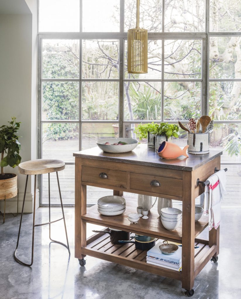 a little freestanding island in recycled pine in front of a large window