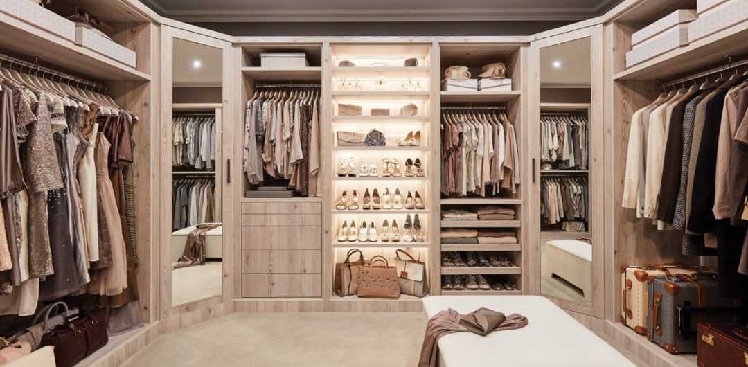 a cream walk-in wardrobe with light wood and shoes and bags hanging up inside it for a feature on how to design a dressing room