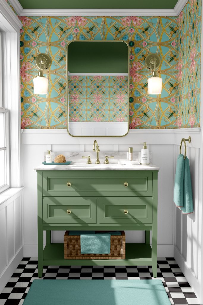 Zelladine Aqua wallpaper in pink and turquoise behind two wall lamps, a rectangular wall mirror and a white basin in a sage green vanity unit