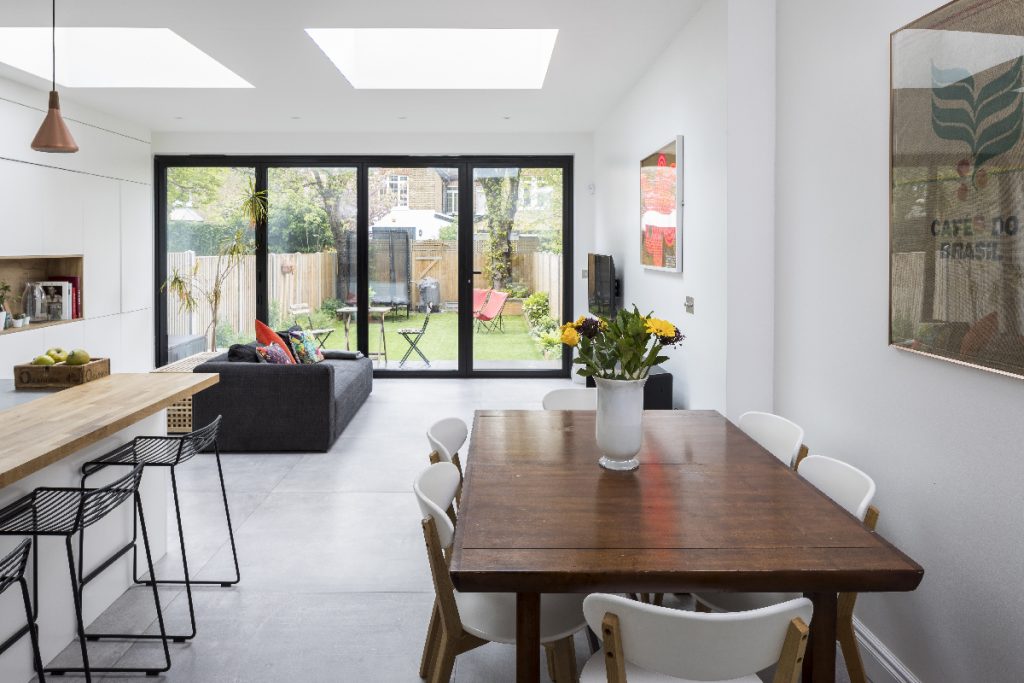 a kitchen extension with bi-fold doors and modern wooden furniture