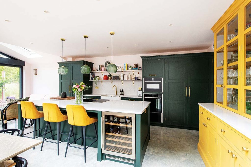 a sustainable yellow and green kitchen featuring yellow cabinetry, green pendant lights and grey marble flooring