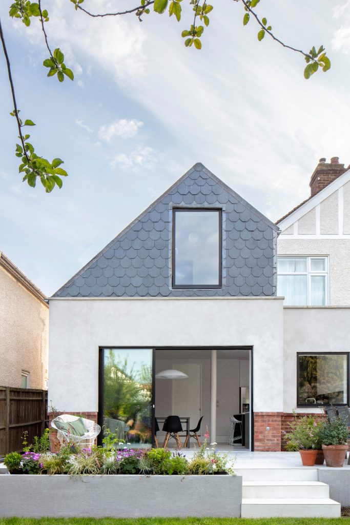 a double-storey kitchen extension on a semi-detached home featuring steps and greenery outside