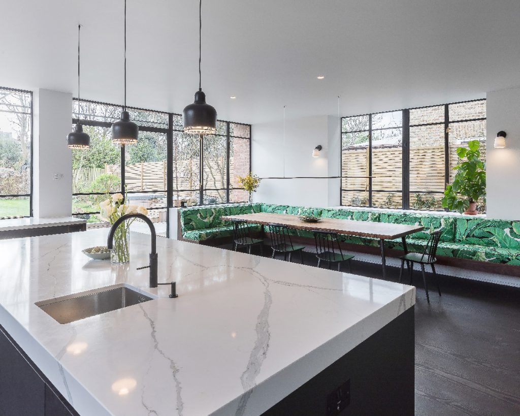 a kitchen extension featuring five metres of banquet seating upholstered in a green palm-leaf fabric