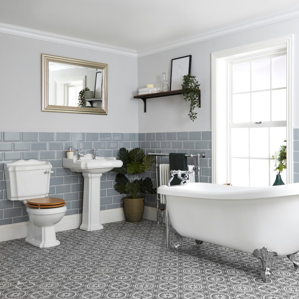 a traditional bathroom featuring monochrome floor tiles, grey wall tiles, a classic three-piece suite and a brass wall mirror
