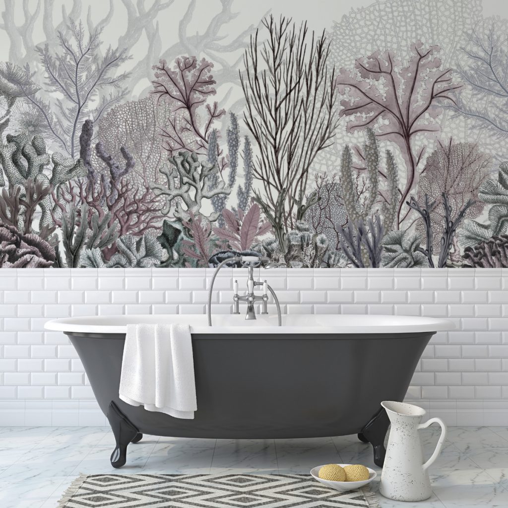 a feature wall in muted colours depicting ocean plants, behind a grey freestanding bath