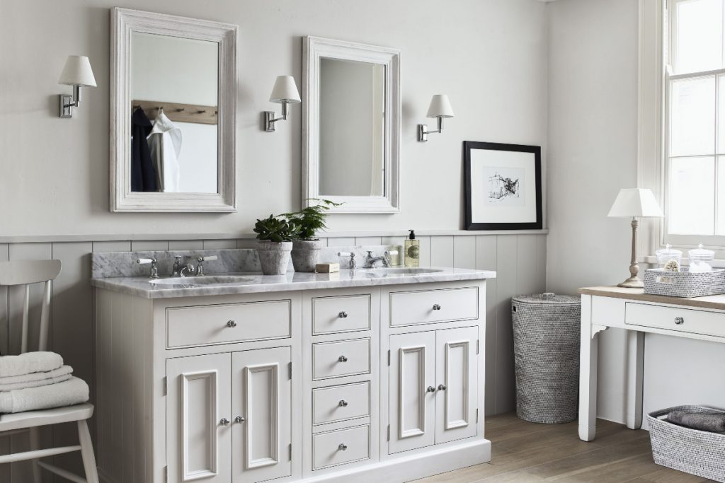 a marble double washstand with panelling and knobs with rectangular wall mirrors above it