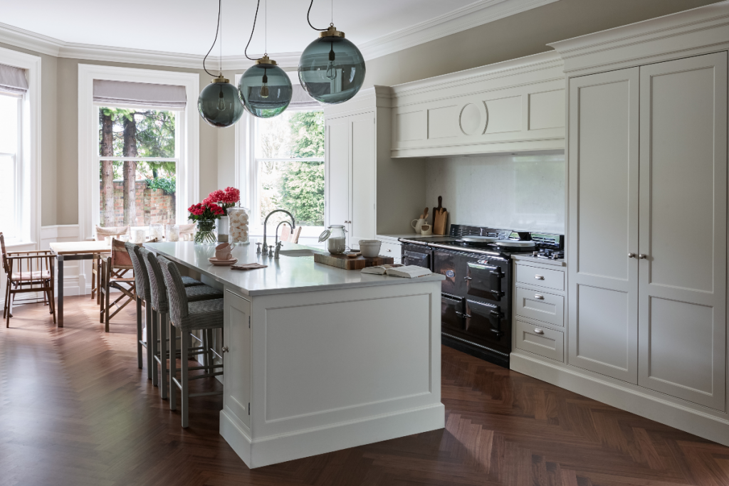 a kitchen layout with a central island and cream Shaker cabinetry around it