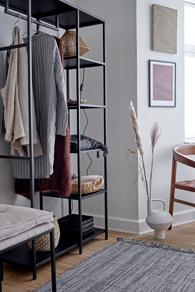 open shelving with clothes hanging on it