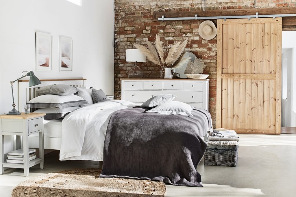 a scandi inspired room with a double bed with grey bedding