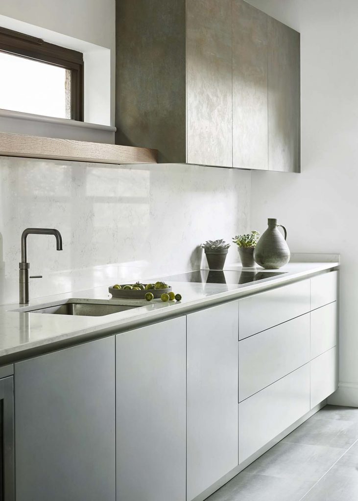 The sink run features handleless cabinetry.