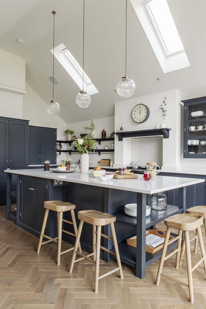 a blue shaker-style kitchen with navy cabinetry and a white kitchen island