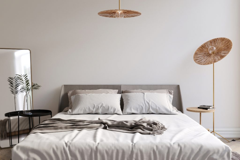 a Scandi inspired guest bedroom featuring natural lampshades and a double bed with neutral bedding