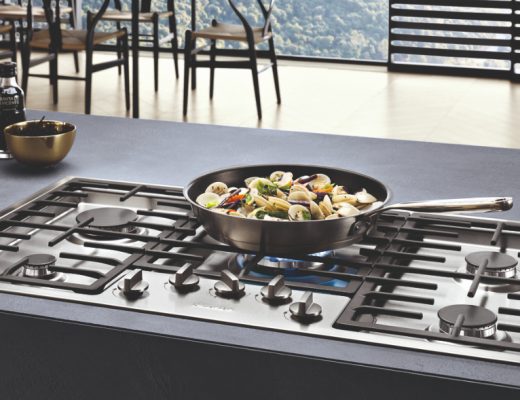 Miele black gas hobs with a pan full of vegetables on a burner