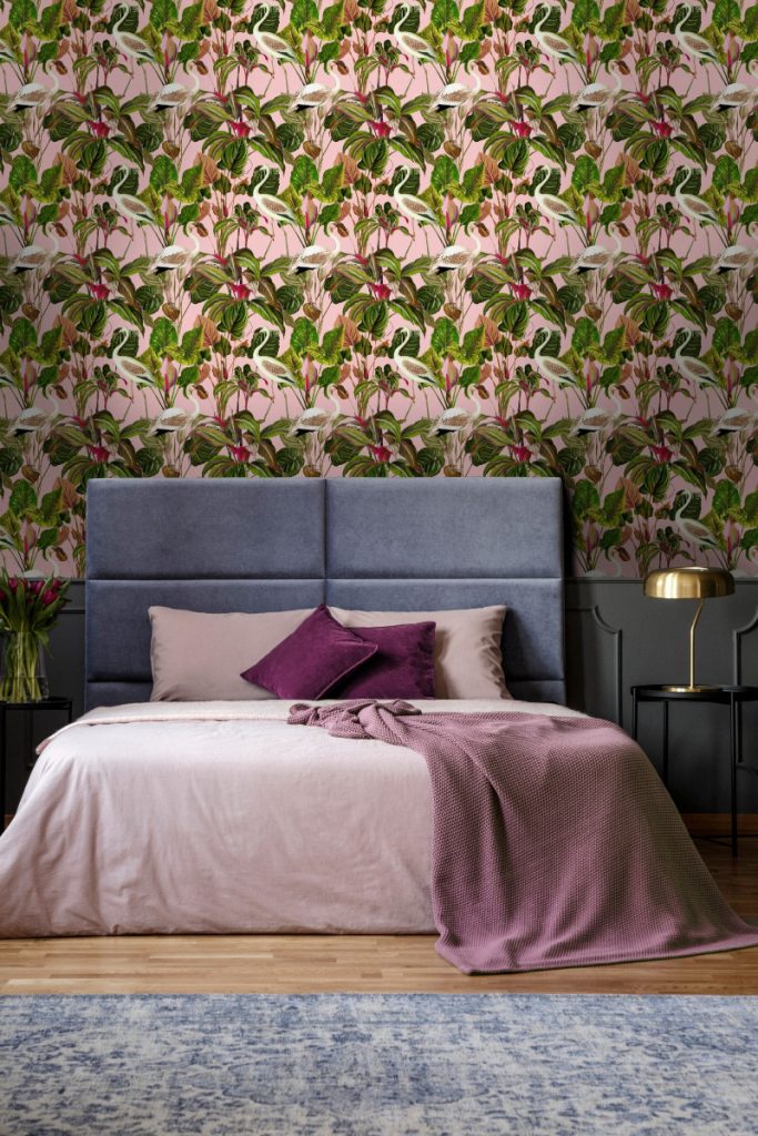 a green and pink floral print featuring flamingos in a bedroom with a navy double bed with pink bedding