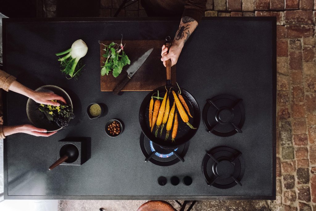 a gas hob with pans of vegetables on it