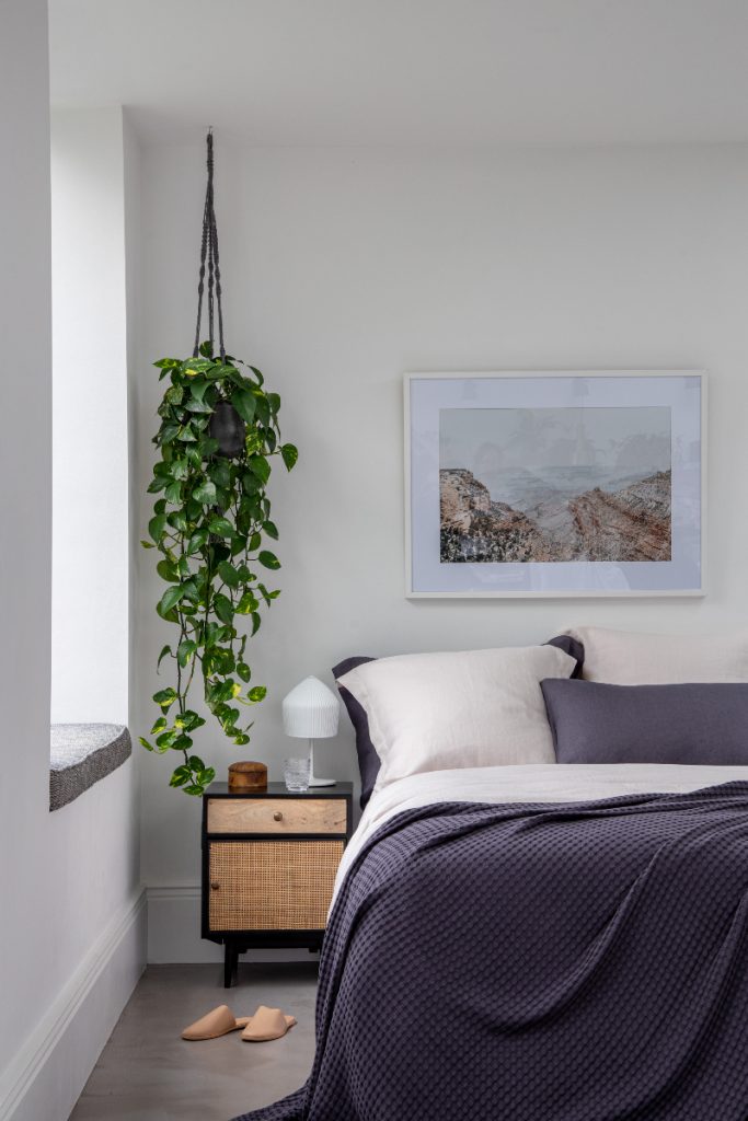 a purple and beige bed linen set under a picture of mountains