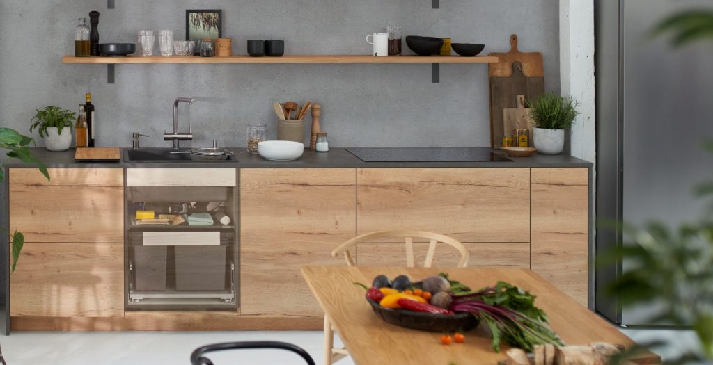 wooden cabinetry under a grey worktop with accessories and crockery on a wooden shelf