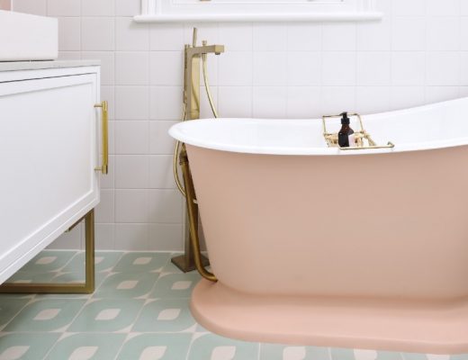 a pink double-ended bath in a traditional bathroom with brass fittings