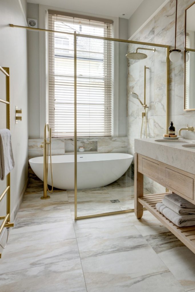 Lapicida's Antique Marble tiles in a bathroom full of brass fittings and a wooden vanity unit