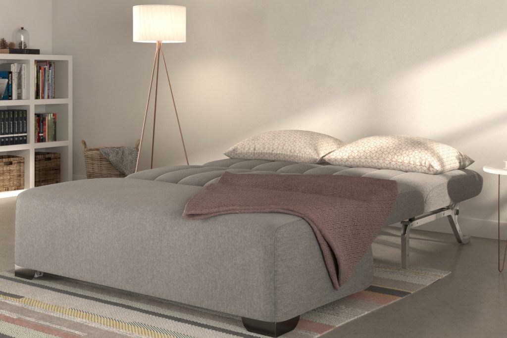 the Bensons for Beds Carina Ash bed in grey with beige cushions and a freestanding wooden lamp next to it with a white shade