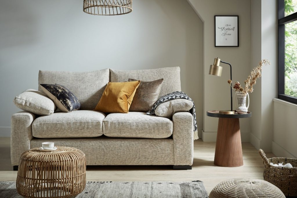 an oatmeal double sofa bed in a beige room with neutral furniture and accessories