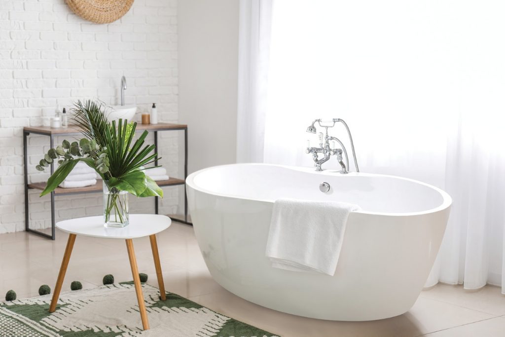 the BC Designs Tamorina Petite tub in white with accessories and plants around it