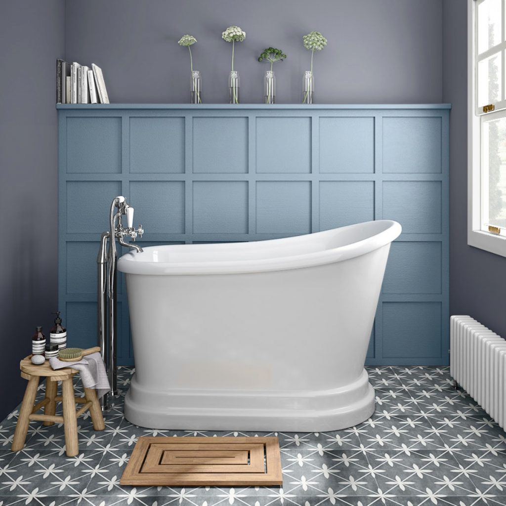 a Victorian‐inspired white gloss acrylic tub in a blue-panelled bathroom with toiletries and accessories