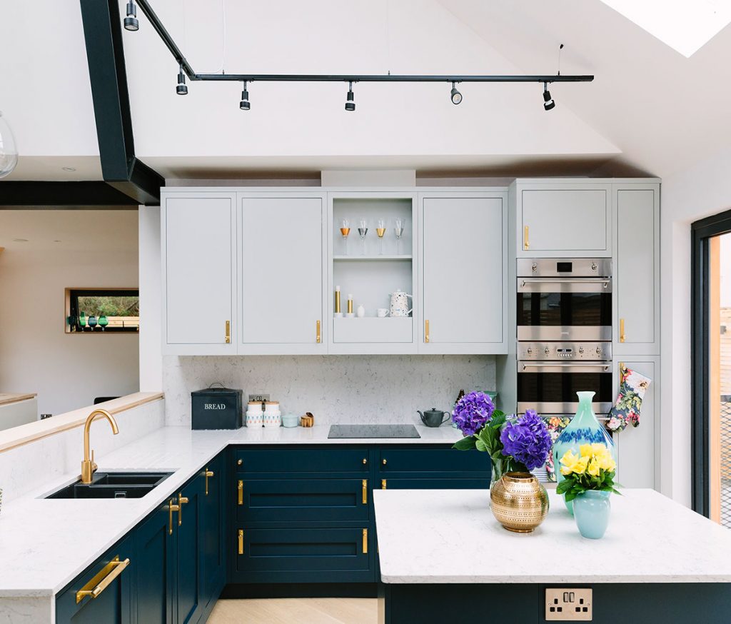 a powder blue kitchen with brass handles and painted teal cabinetry designed by virtual design services