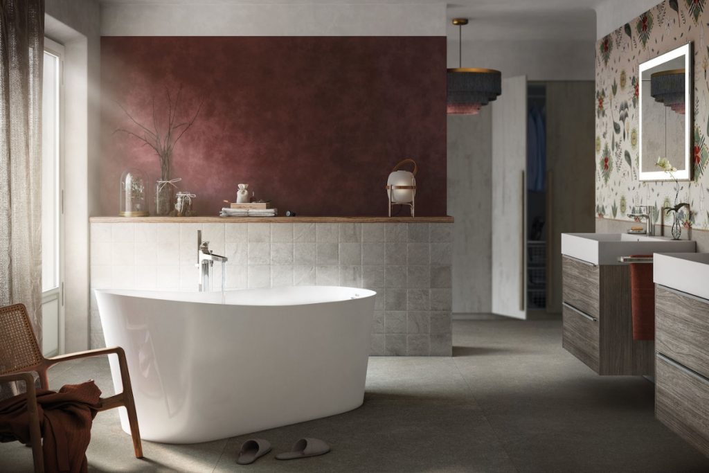 a white Roca Maui round Stonex tub  in a red bathroom with twin sinks in walnut with silver handles