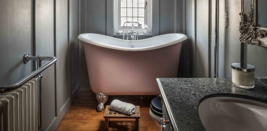 a bronze compact bath in a traditional Victorian bathroom with toiletries and accessories