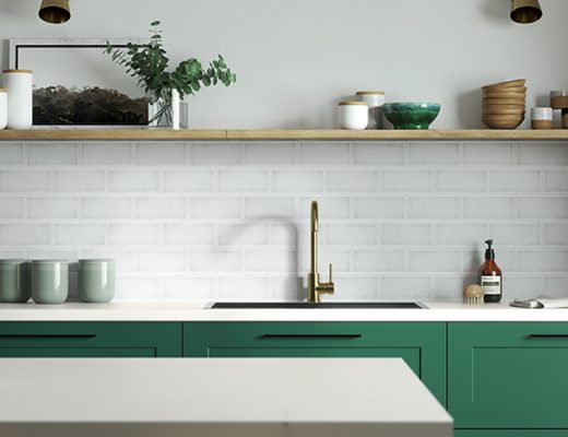 a jade green kitchen with white tiles and brass hardware to illustrate the question of how much a kitchen costs