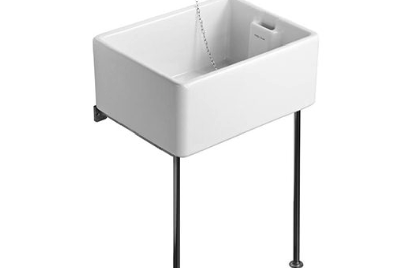 a white Belfast sink on black legs with taps above it