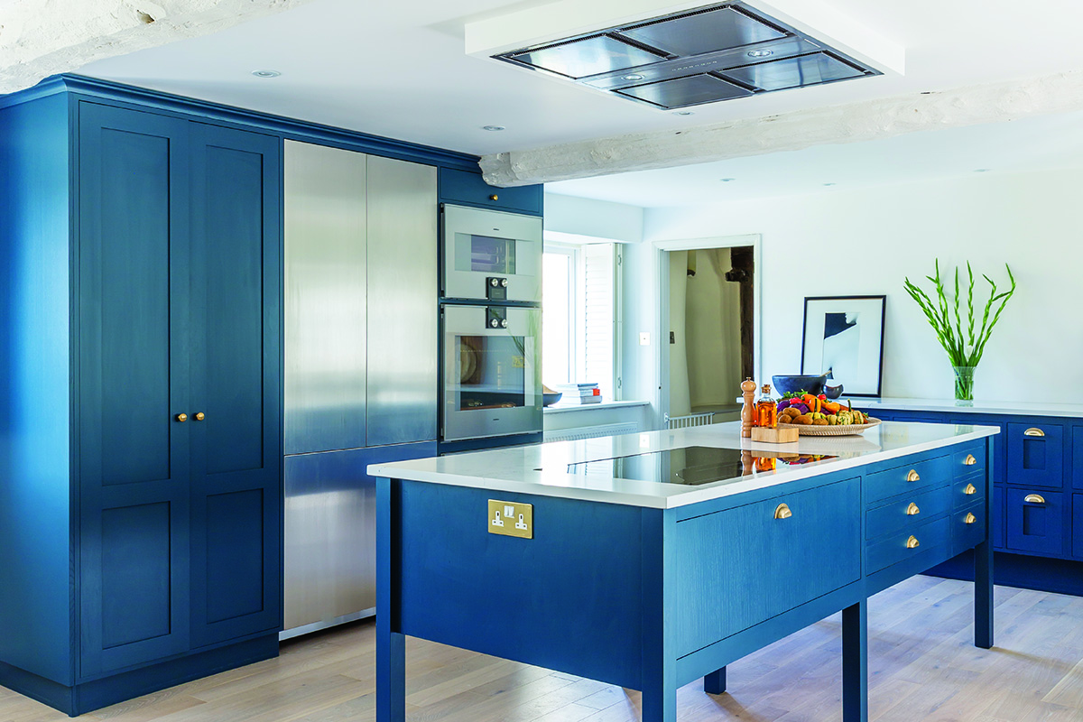 a blue kitchen with brass cup handles