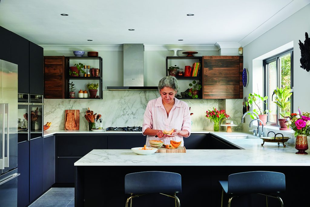 a woman preparing food at a white marble kitchen worktop 