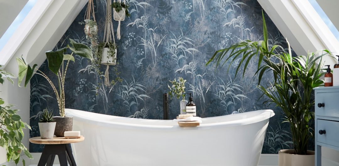 floral blue wallpaper in a bathroom above a white freestanding bath