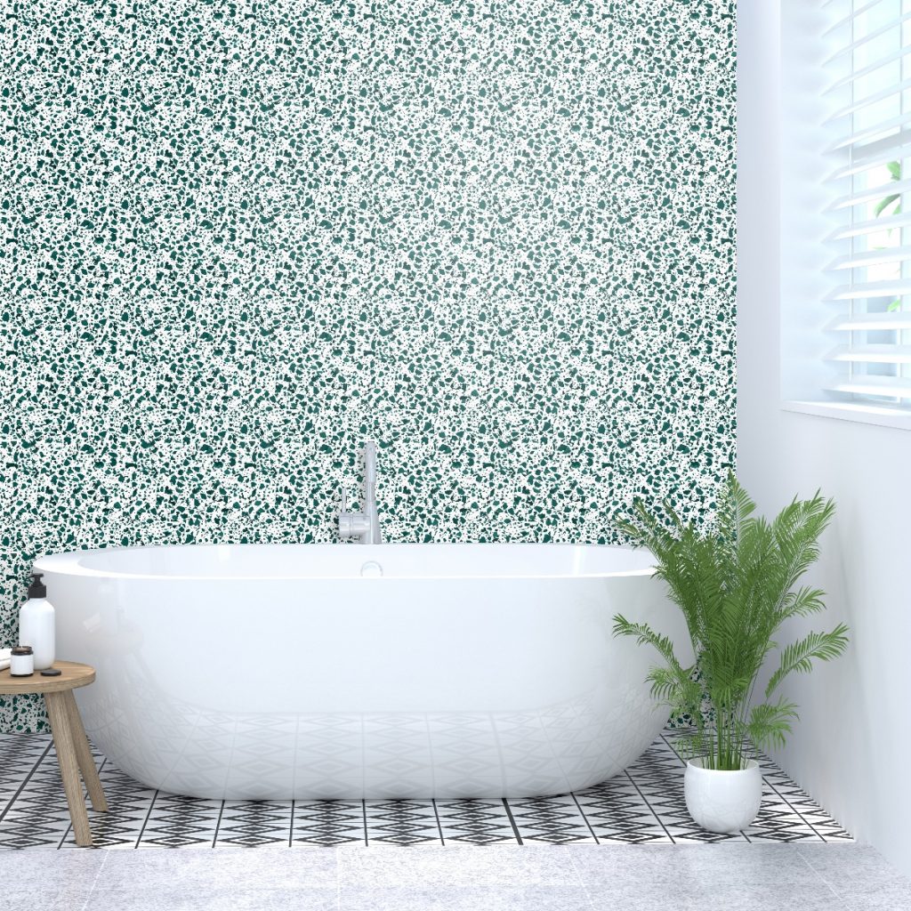 a green floral design behind a white freestanding tub